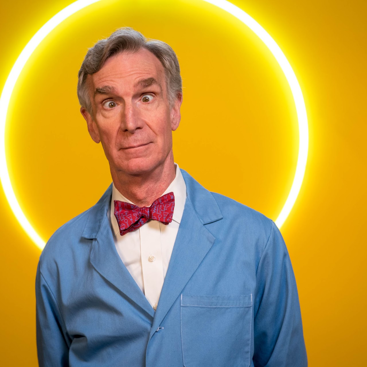 an older guy in a blue science coat with a red bow tie with a yellow background 